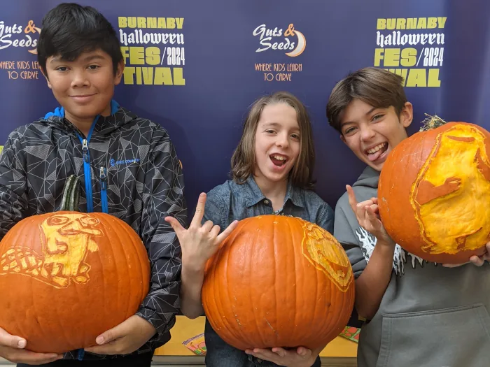 Kids showing their finished carved pumpkins